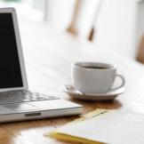 Tasse de café placée à côté d'un ordinateur protable