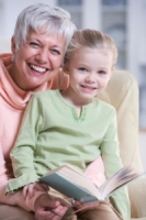 Mamie lit un livre à sa petite fille, elles ont le sourire
